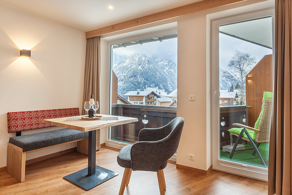 Doppelzimmer Standard Plus B - Wohnzimmer mit Balkon - Almajur Ferienhotel Mittelberg Kleinwalsertal